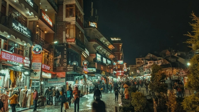 a group of people walking down a street next to tall buildings